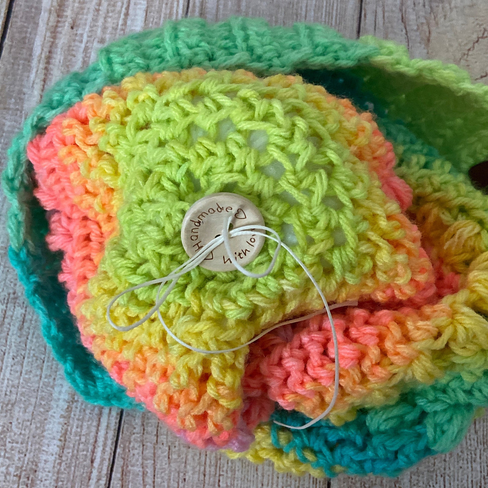 Photo of pom pom attachment for handmade hat - button closure with button that says "handmade with love" and wax coated thread for security
