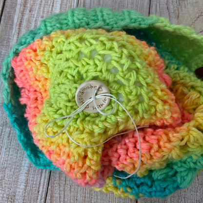 Photo of pom pom attachment for handmade hat - button closure with button that says "handmade with love" and wax coated thread for security